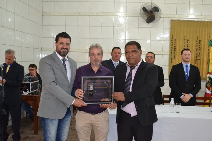 Prefeito Adriano dos Santos e presidente da Câmara Guilherme Barão fizeram a entrega de uma placa ao homenageado Vagner Pinto