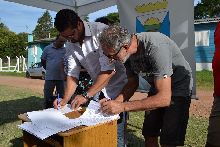 Prefeito Adriano e o morador Leonel de Figueiredo assinam o contrato